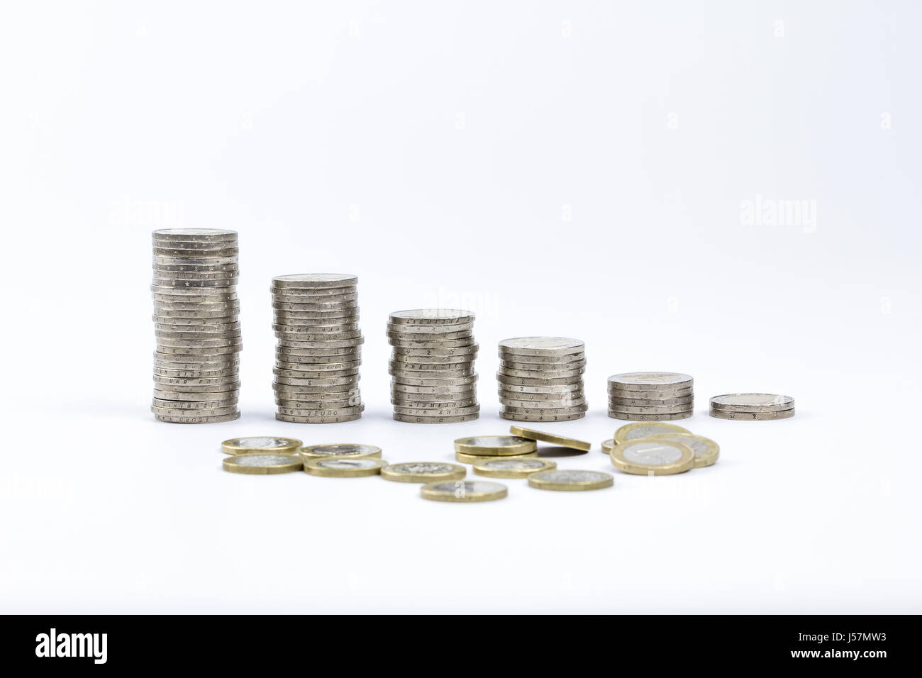 2 Euro-Münzen gestapelt und verstreut einige von 1 Euro auf einem weißen Hintergrund isoliert Stockfoto
