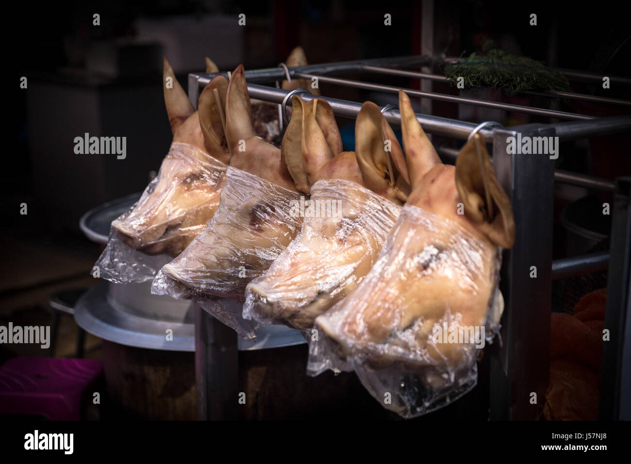 Schwein-Köpfe eingewickelt in Alufolie in ein Fleisch-Markt Stockfoto