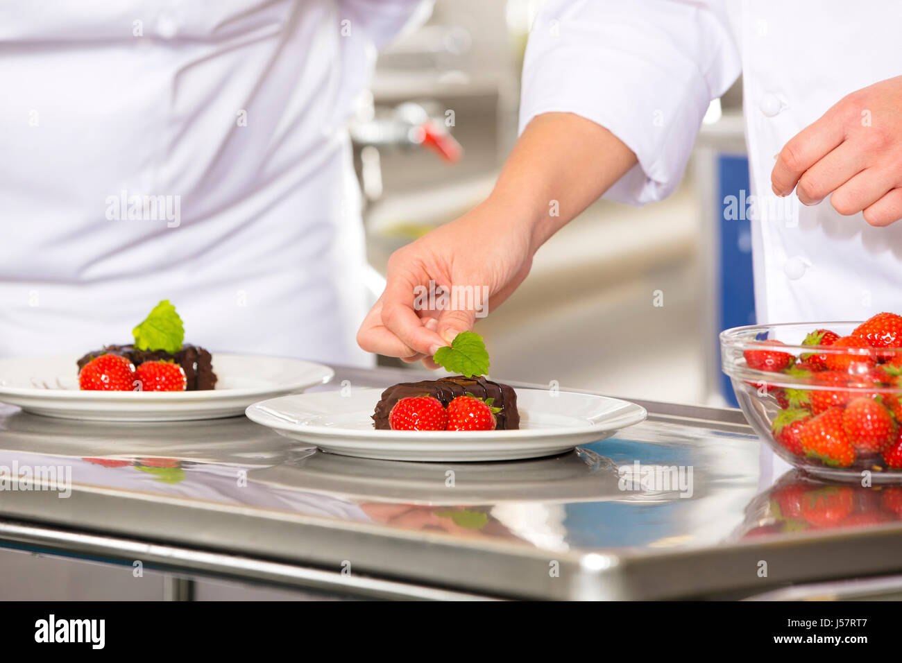 Profi-Koch dekorieren Kuchen Dessert mit Erdbeeren Stockfoto