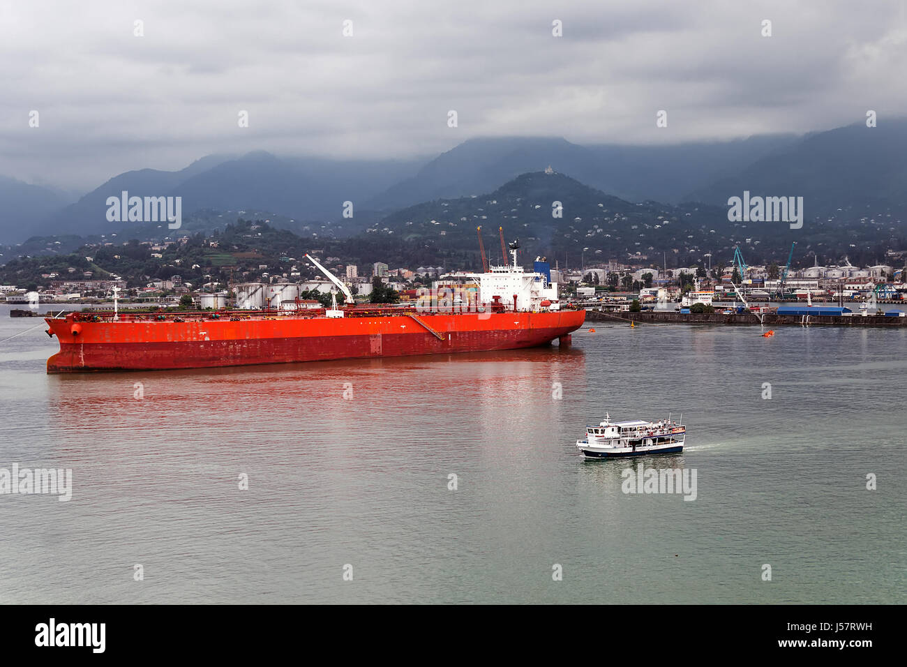 Ozean-Frachtschiff und kleine Touristenboot geschützt vor einem Sturm in der Bucht des Hafens, Batumi, Georgien Stockfoto