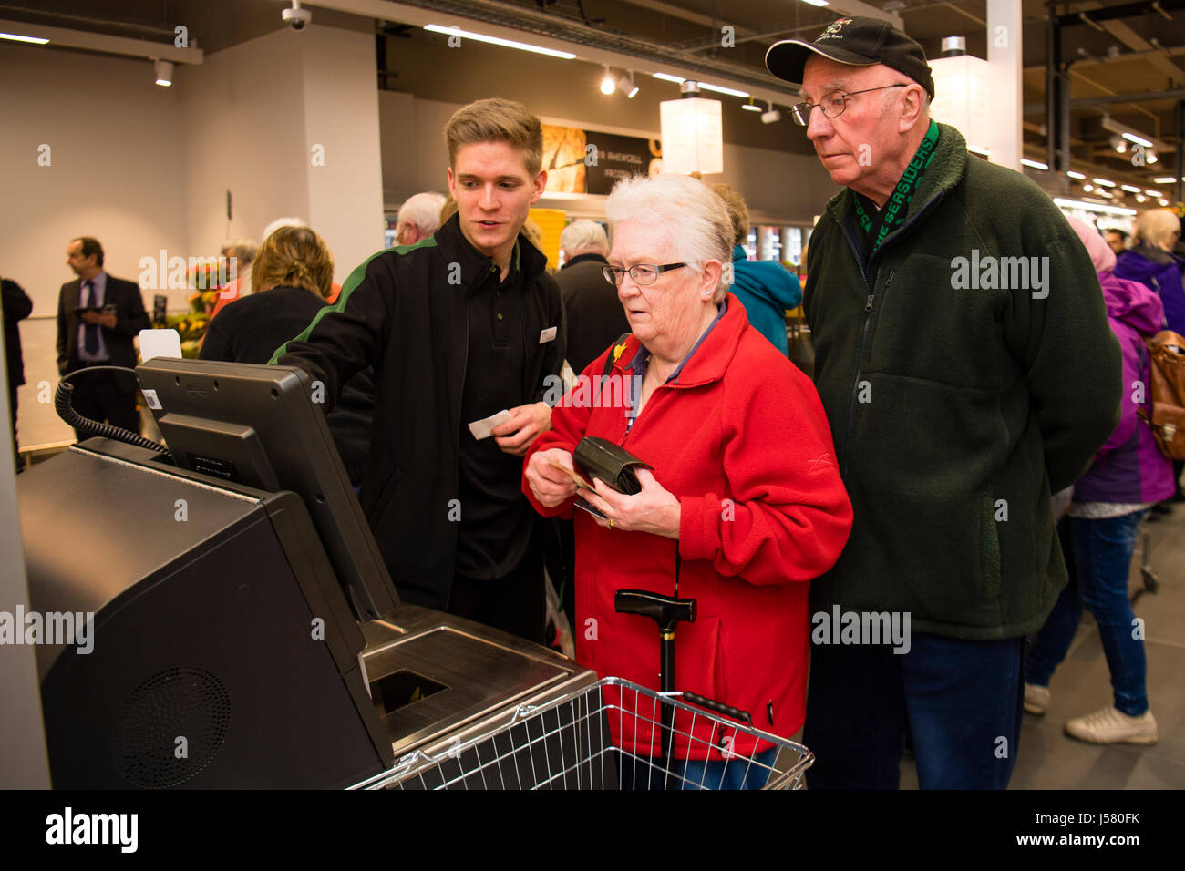 Menschen erhalten Hilfe und Unterstützung von einem Mitarbeiter im Umgang mit der SB-Kasse in der Food Hall in Marks and Spencer speichern, Aberystwyth Wales UK Stockfoto