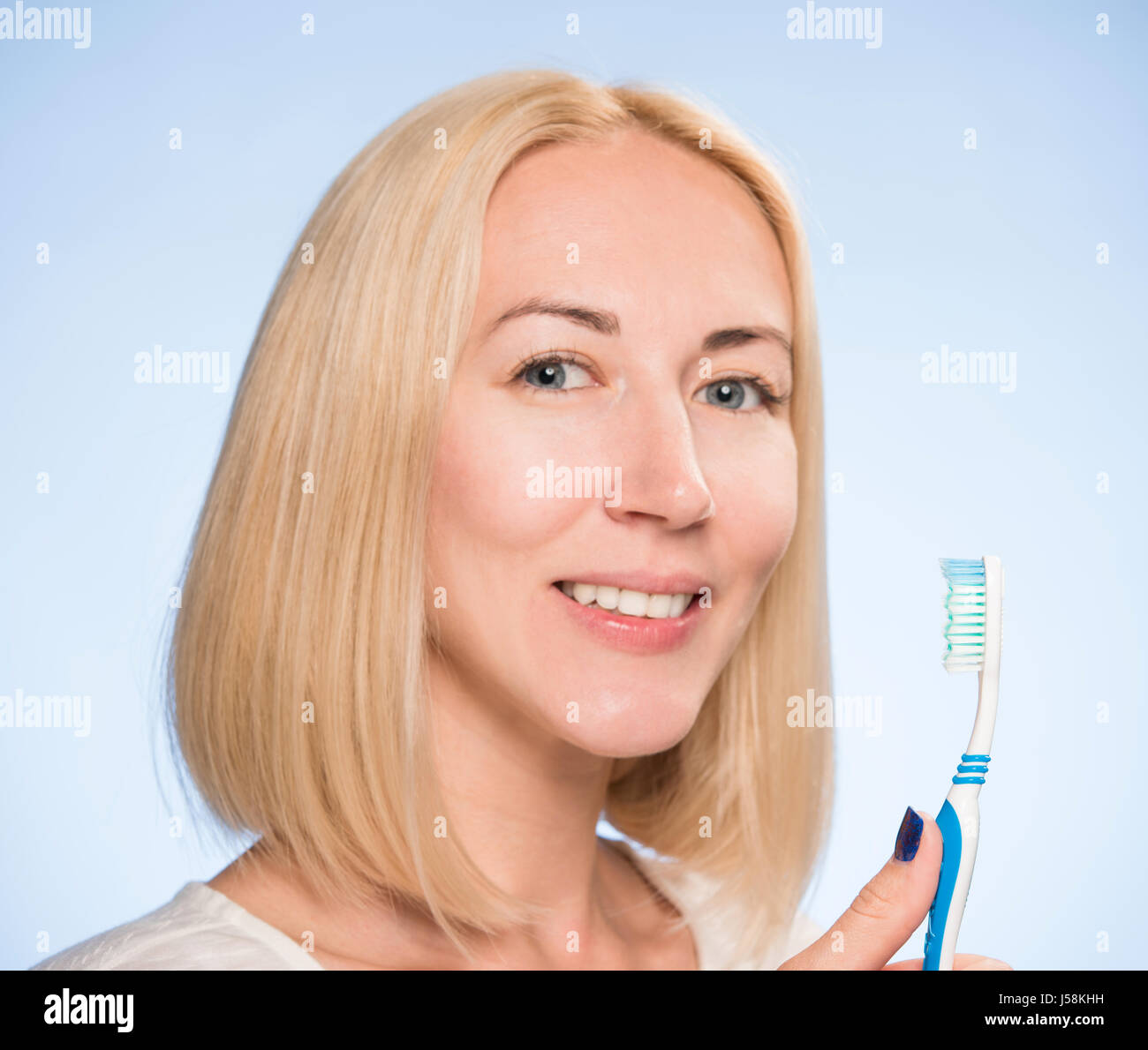 schöne Blondine reinigt die Zähne Stockfoto
