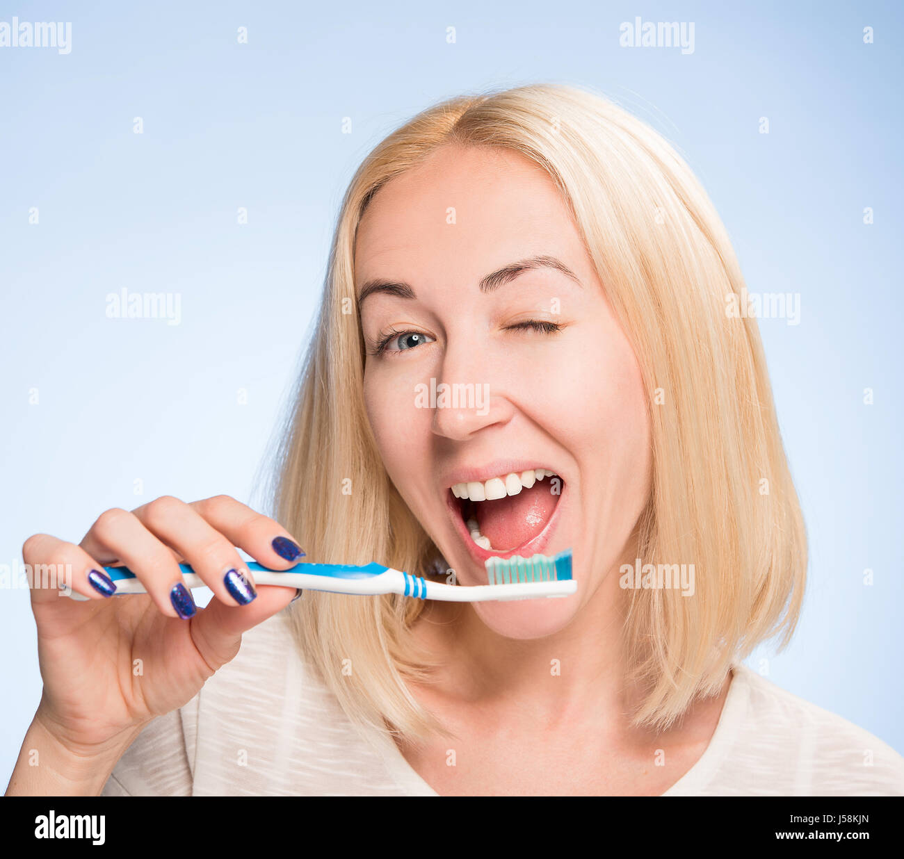 schöne Blondine reinigt ein Glanz-Zähne Stockfoto