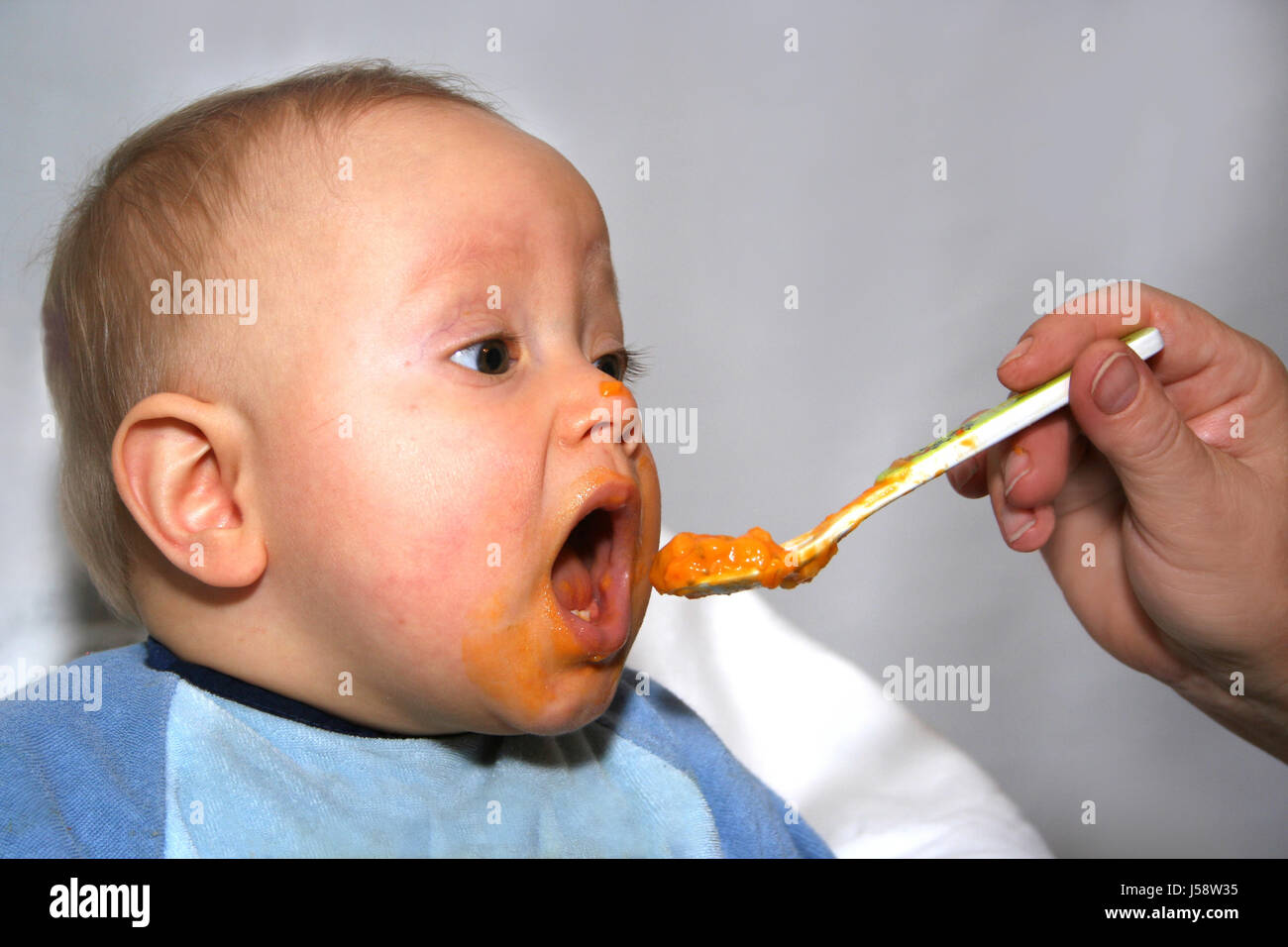 Hand männliche maskuline Porträt Baby Futter Einnahme Pap-Babynahrung essen Essen Stockfoto