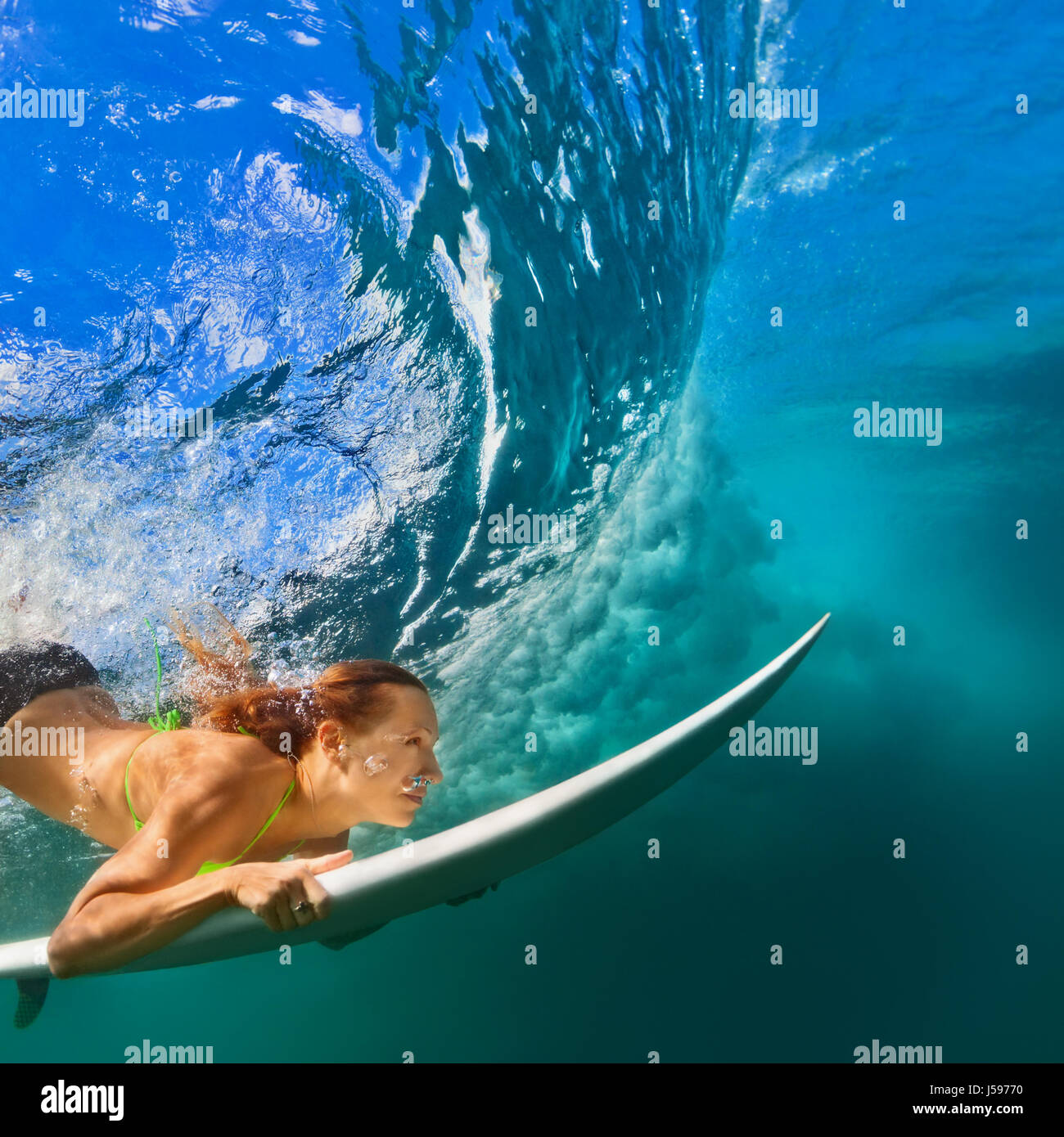 Aktive Mädchen im Bikini in Aktion. Surfer-Frau mit Surf Board Tauchgang  unter Wasser unter brechen große Welle. Gesunde Lebensweise. Wassersport,  Extreme Surfen Stockfotografie - Alamy