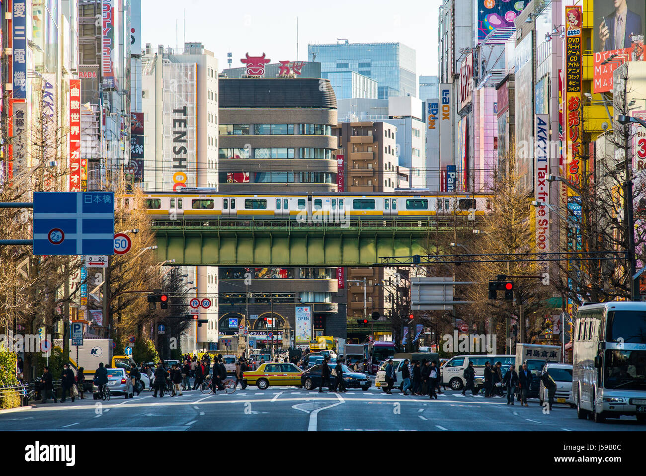 Nach unten die breite Straße in Akihabara electric city, Tokio, Japan, während bei Besetzt tagsüber. Menschen kreuz während einer u-Overhead Segel Stockfoto