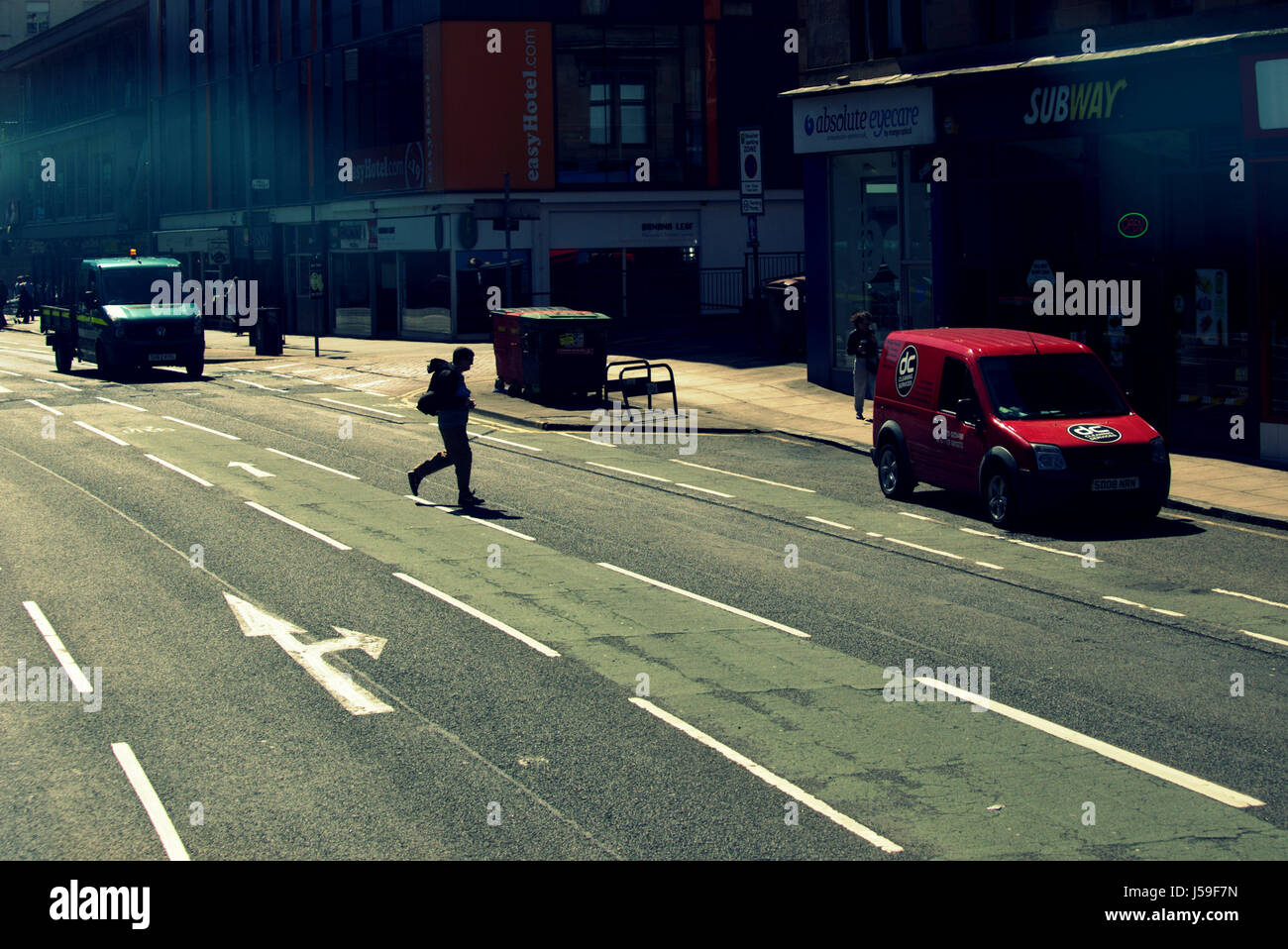 Mann Silhouette Kreuzung Straße beleuchtet wieder Jay walking Stockfoto