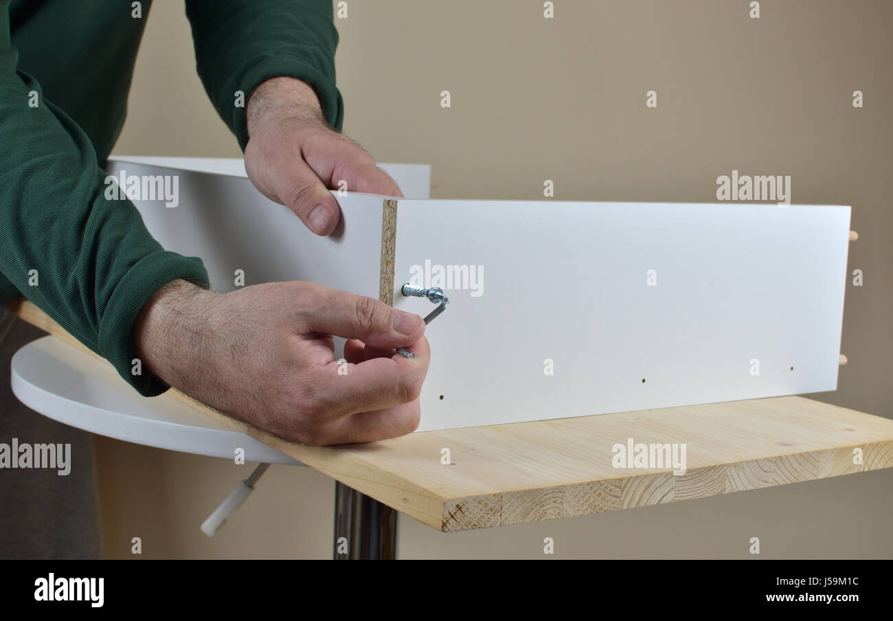 Befestigung von zwei Spanplatten mit einer Schraube mit Innensechskant-Schlüssel - Nahaufnahme Stockfoto