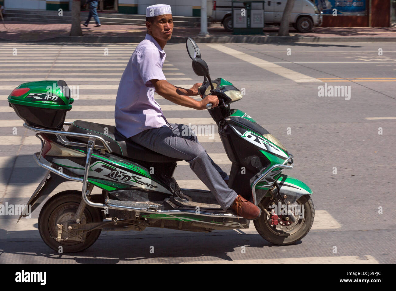 Chinesischen ethnischen Hui Mann auf dem Motorrad, Guyuan, Ningxia, China Stockfoto
