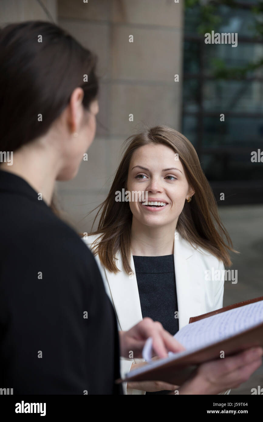 Porträt von zwei kaukasischen Geschäftsfrauen außerhalb modernen Büro Buidling sprechen. Stockfoto