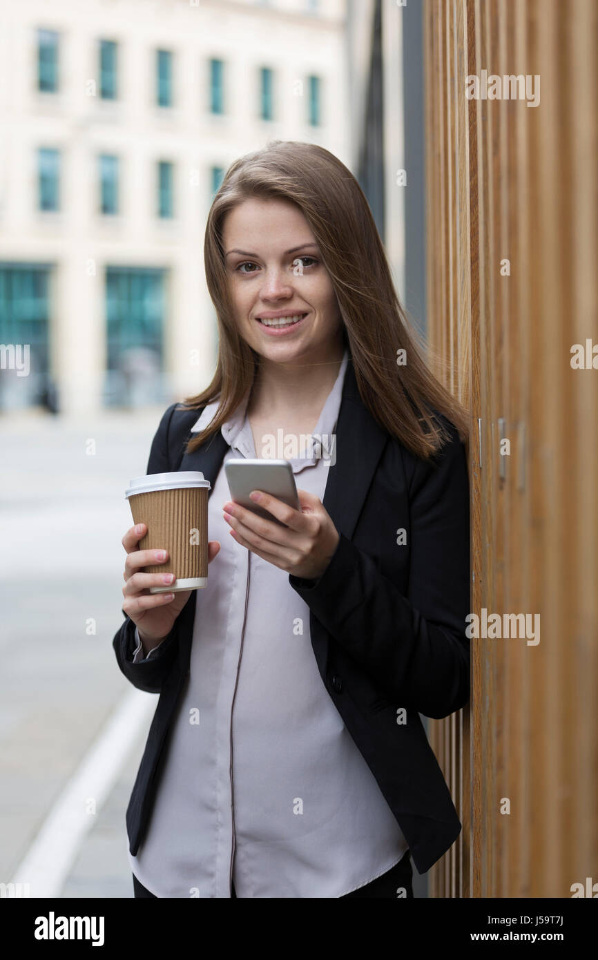 Glücklich kaukasischen Geschäftsfrau mit ihrem Smartphone.  Business-Frau in modernen Stadt draußen. Stockfoto