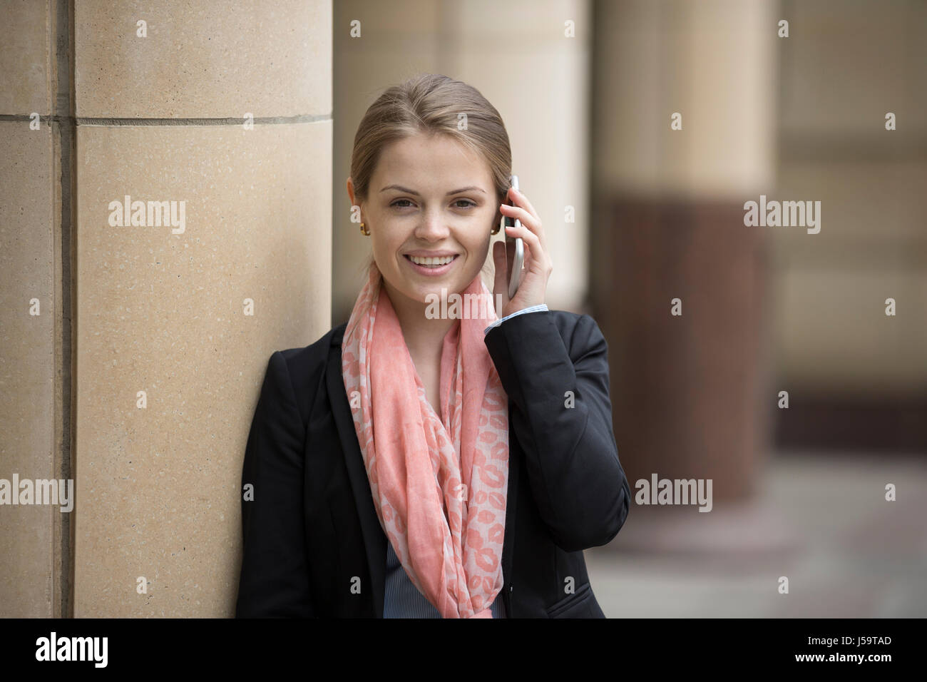 Glücklich kaukasischen Geschäftsfrau mit ihrem Smartphone.  Business-Frau in modernen Stadt draußen. Stockfoto