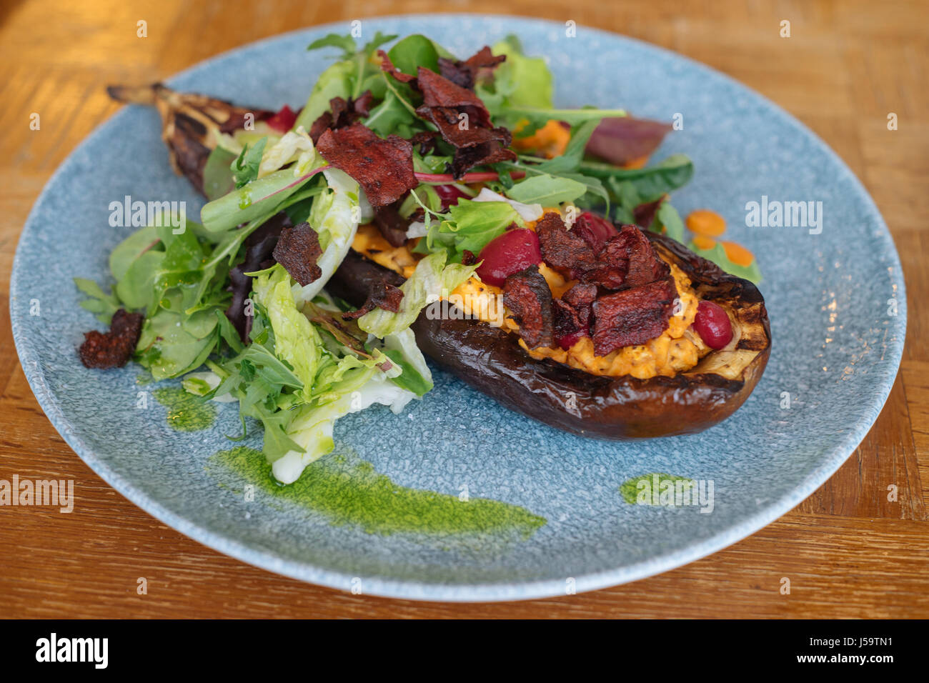 Gebackene Auberginen mit frischem Salat, Karotten Sahne und Gemüse Chips. Vegane Küche Stockfoto