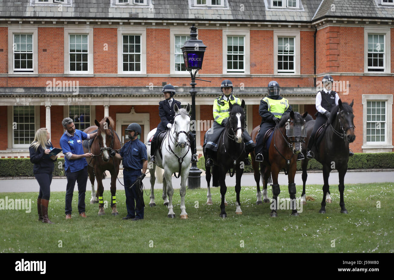 Blue Cross Mark Bossley vet (2. von links) und Blue Cross Offizier Gemma Taylor inspizieren Pferde aus dem Metropolitan Police montiert Zweig, dessen Fahrer in verschiedenen Uniformen, außerhalb der alten Polizeistation im Hyde Park, London als Bestandteil der Wohltätigkeitsorganisation National Equine Health Survey, die 22-29 Mai läuft gekleidet. Stockfoto