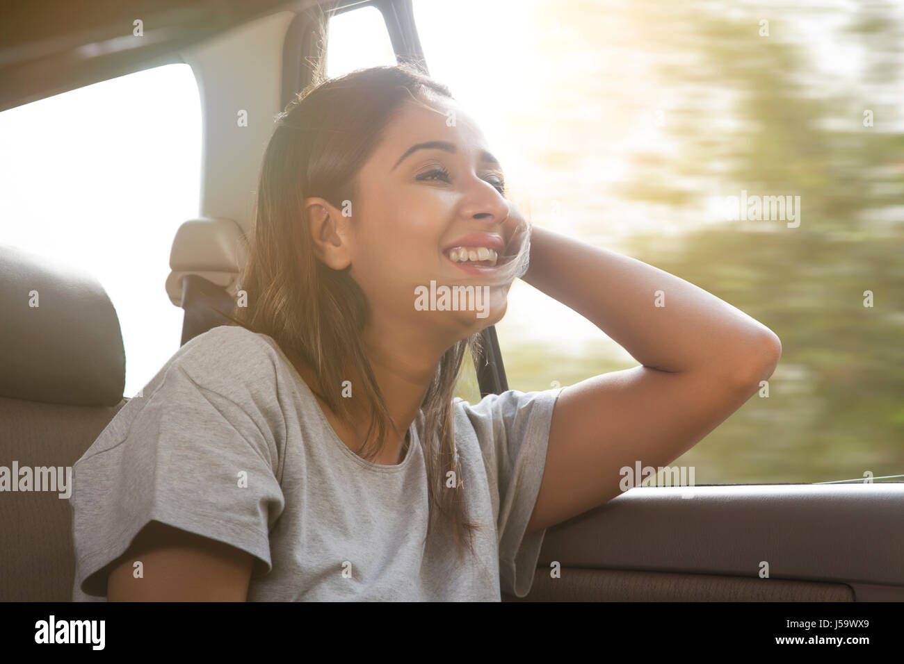 Lächelnde junge Frauen im Auto Haar bekommt durch den Wind geblasen. Stockfoto