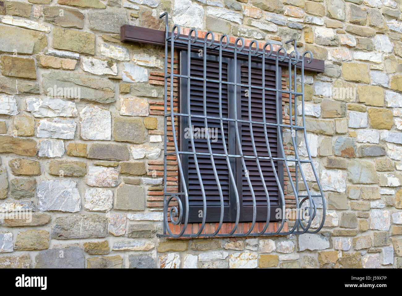 Fenster mit Eisengitter auf Steinmauer Stockfoto