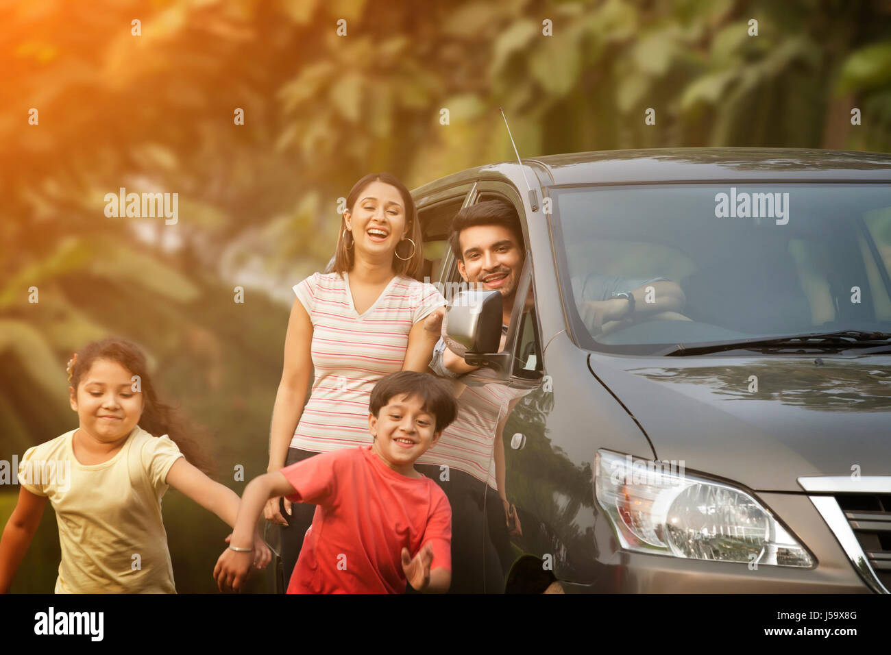 Glückliche Kinder läuft aus Auto Stockfoto