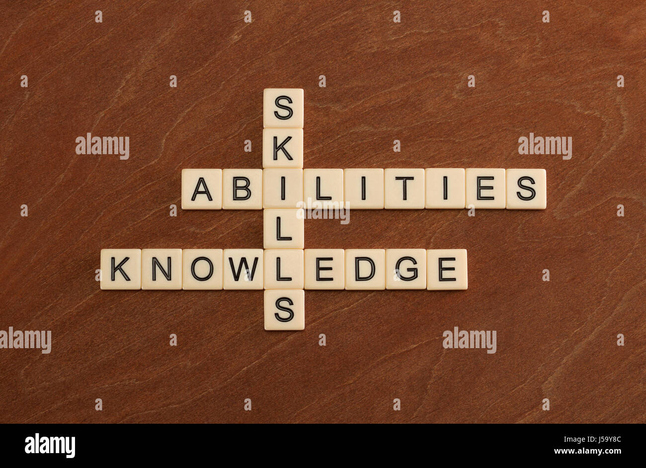 Kreuzworträtsel mit Worten Fertigkeiten, Fähigkeiten, wissen. Learning-Konzepts. Elfenbein Fliesen mit Großbuchstaben auf Mahagoni Brett. Stockfoto
