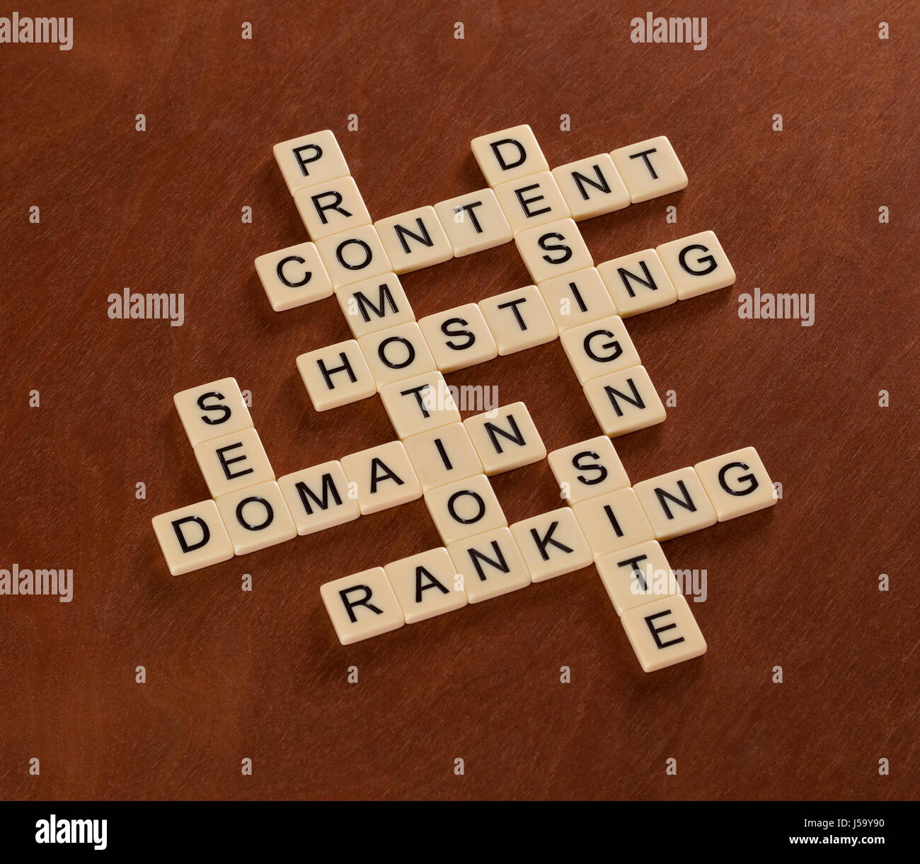 Kreuzworträtsel mit Worten SEO, Website, Inhalte, Ranking. Website-Erstellung-Konzept. Elfenbein Fliesen mit Großbuchstaben auf Mahagoni Brett. Stockfoto