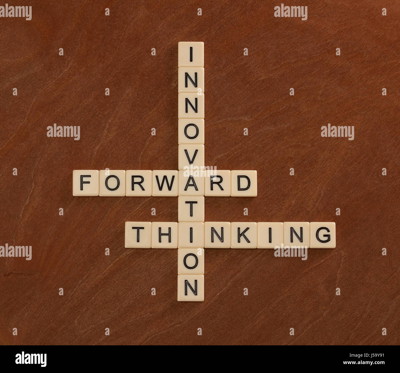 Kreuzworträtsel mit Worten Innovation, Forward, denken. Innovativ sein Konzept. Elfenbein Fliesen mit Großbuchstaben auf Mahagoni Brett. Stockfoto