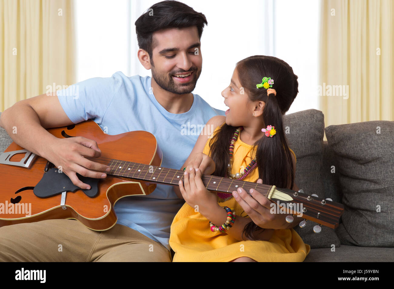 Vater Lehre Tochter, Gitarre zu spielen Stockfoto