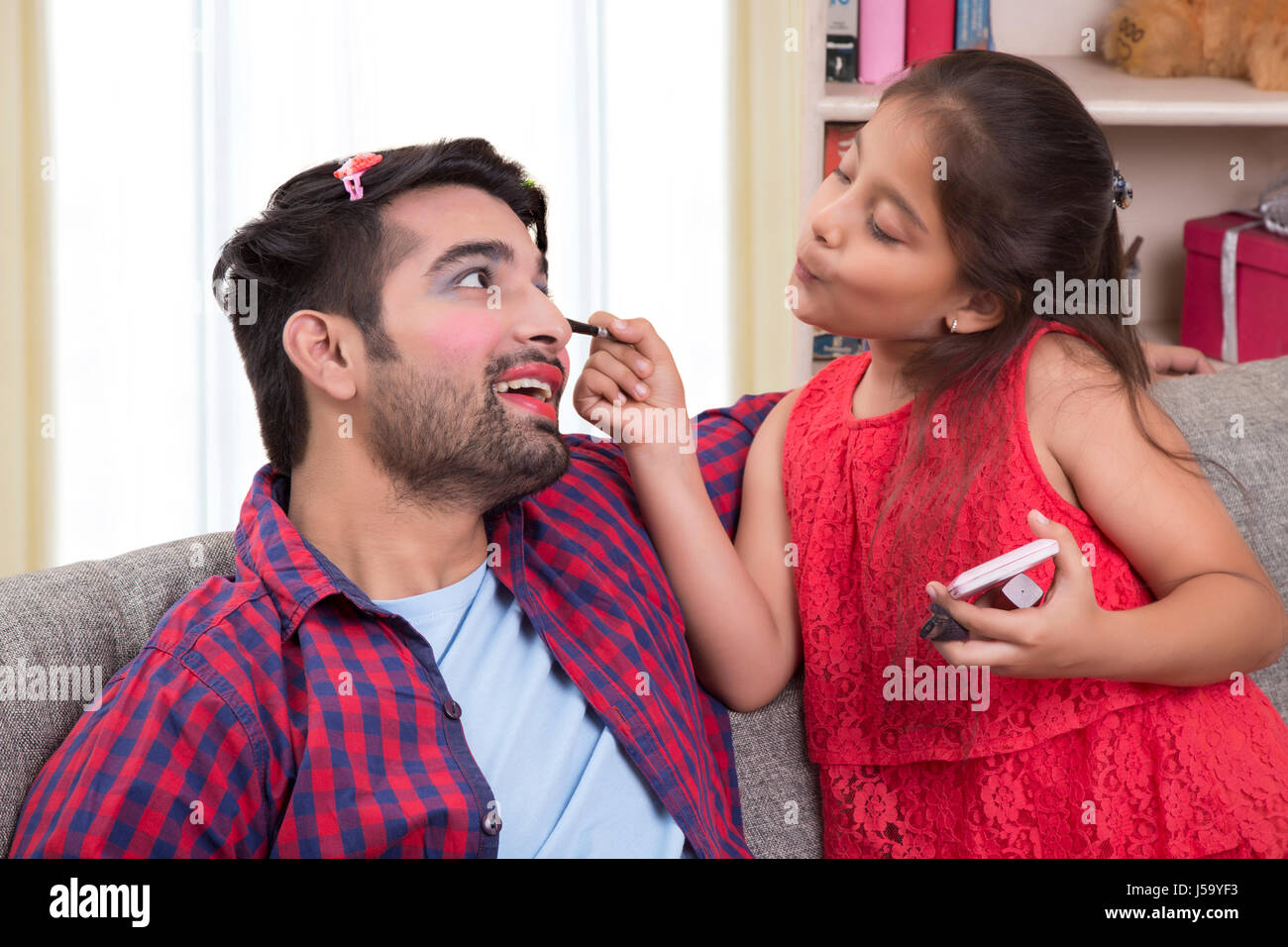Tochter Anwendung Make-up zu ihrem Vater Stockfoto