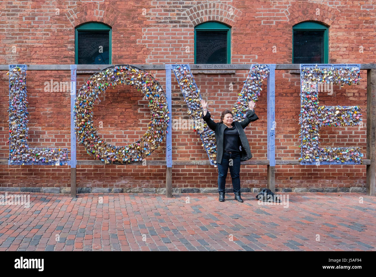 Tourist vor dem Mathew Rosenblatt Wort Liebe geschrieben mit Schlössern, Vorhängeschlösser, Liebe Symbol, Liebeskonzept, valentine, The Distillery District, Toronto. Stockfoto