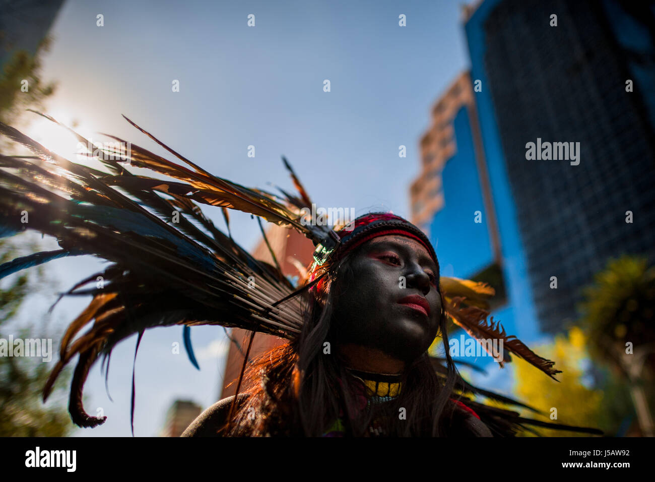 Ein mexikanisches Mädchen tragen eine bunte Feder Kopfbedeckungen inspiriert von Azteken, beteiligt sich an den Tag der Toten Prozession in Mexico City, Mexiko. Stockfoto