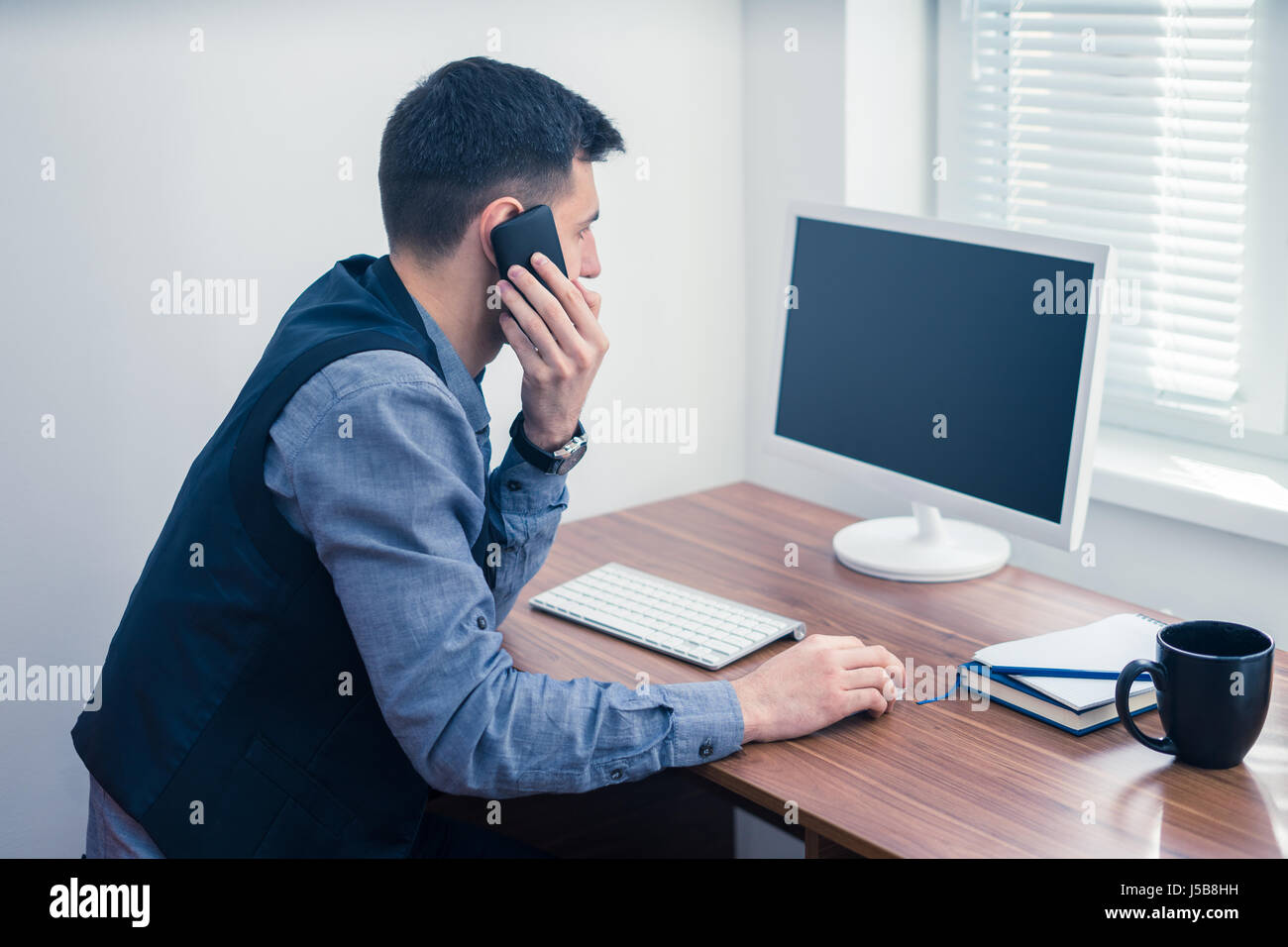 Büroangestellter nimmt eine Bestellung per Telefon Stockfoto