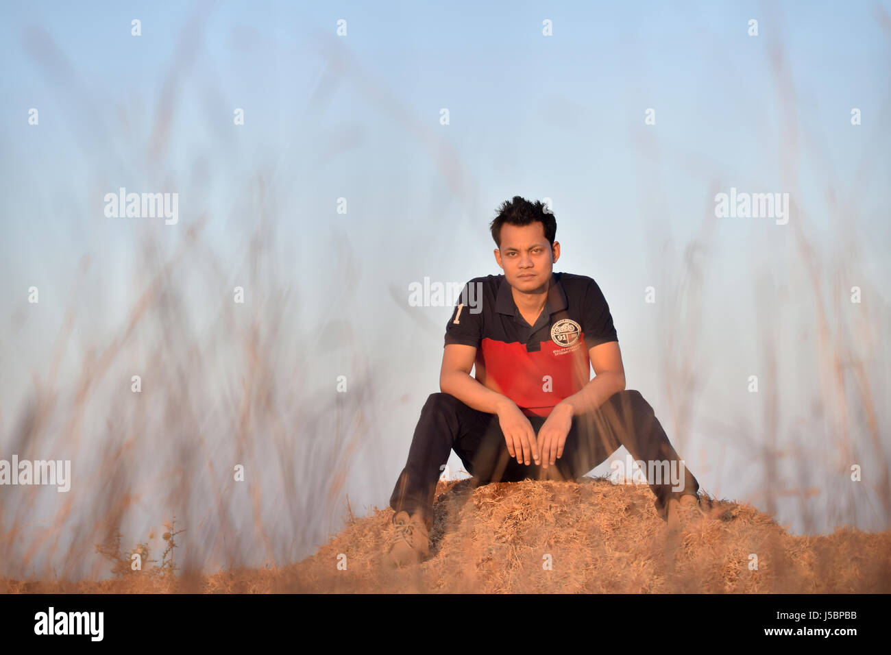 Junger Mann sitzt in der Nähe von Berg, Pune, Maharashtra Stockfoto