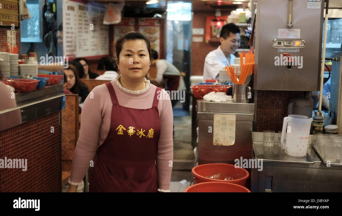 Server der Kellnerin im Restaurant in Mongkok Kowloon Hong Kong China Asien trägt eine rote Schürze Stockfoto