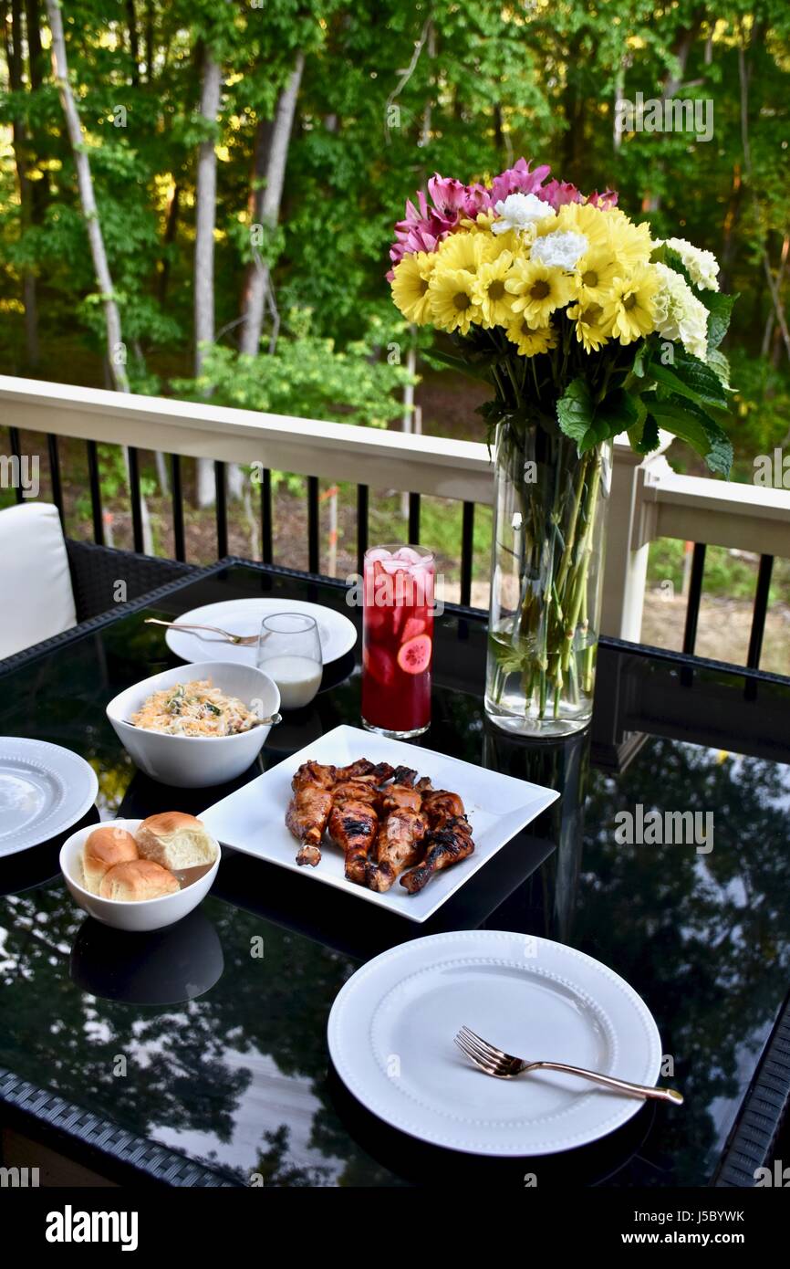 Außengastronomie mit BBQ Chicken Drumsticks, Abendessen Brötchen, Nudelsalat, und Eistee Stockfoto