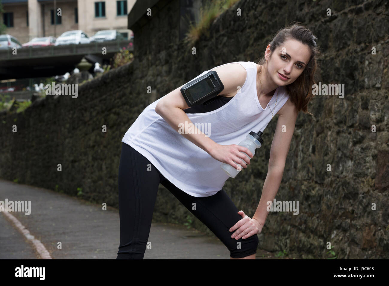 Sportliche Frau Trinkwasser, während Training draußen in einer natürlichen Umgebung. Aktion und gesunden Lifestyle-Konzept. Stockfoto