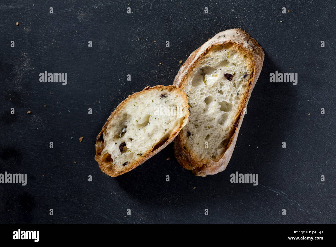 Zwei Scheiben Brot Brot auf einem schwarzen Schiefer-Brett. Stockfoto