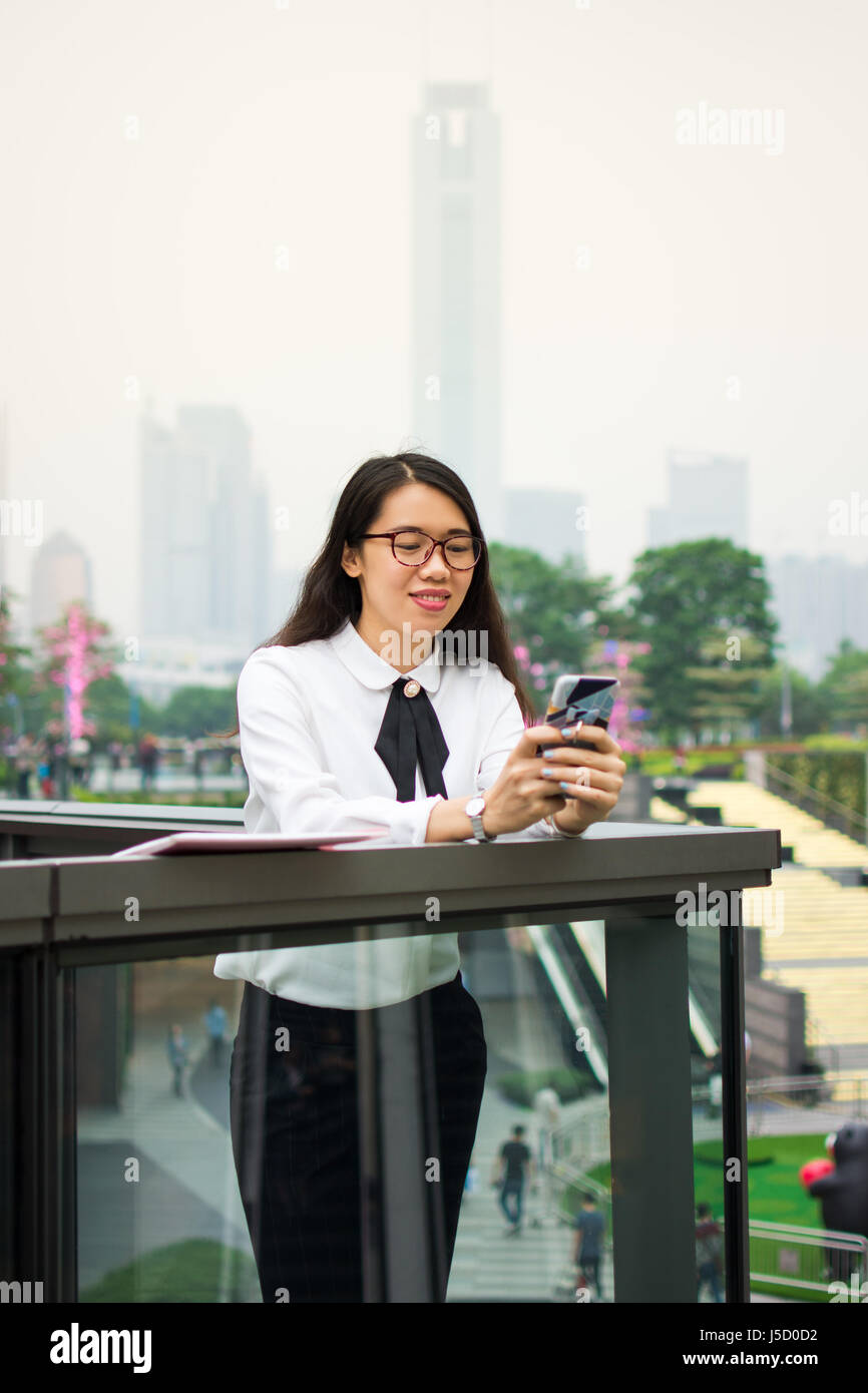 Business Frau SMS in moderner Umgebung im freien Stockfoto