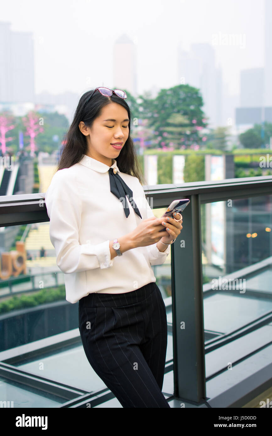 Business Frau SMS in moderner Umgebung im freien Stockfoto