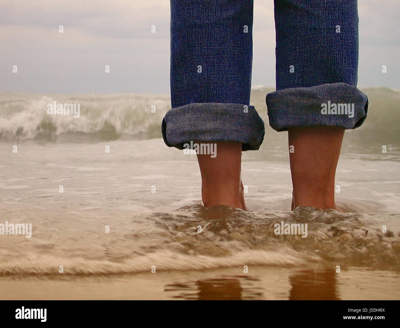 Frau Beine am Strand am Meer Strand Meer Wellen Erfrischung Jeans Hosen  Stockfotografie - Alamy