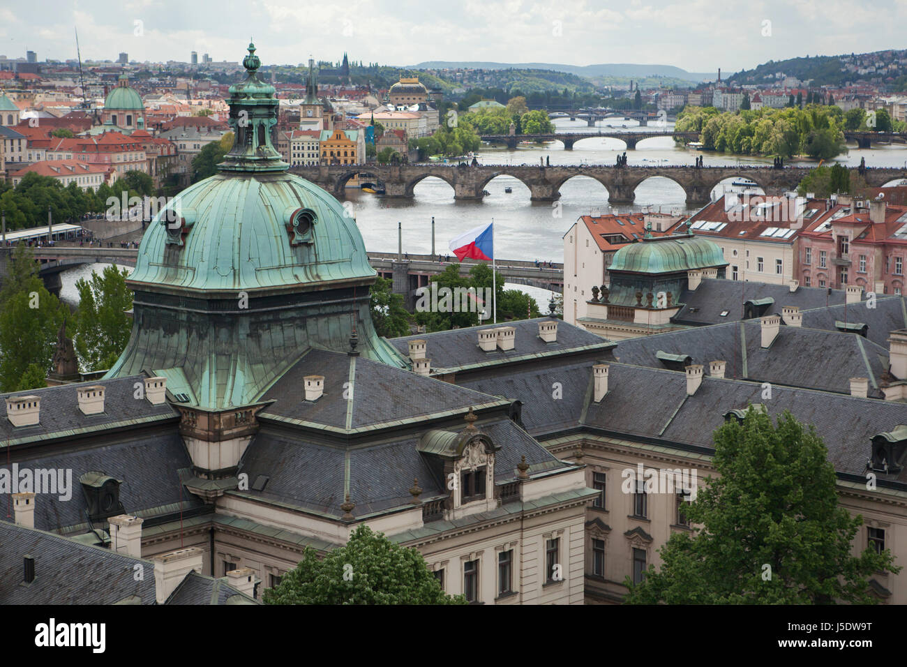 Karlsbrücke und andere Brücken über die Moldau aus dem Garten der Villa Kramář (Kramářova Vila) in Prag, Tschechische Republik abgebildet. Im Vordergrund sieht man die Kuppel der Académie Straka (Strakova Akademie). Die Gebäude des tschechischen Architekten Václav Roštlapil wurde 1891-1896 erbaut und diente nun als Sitz der Regierung der Tschechischen Republik. Stockfoto