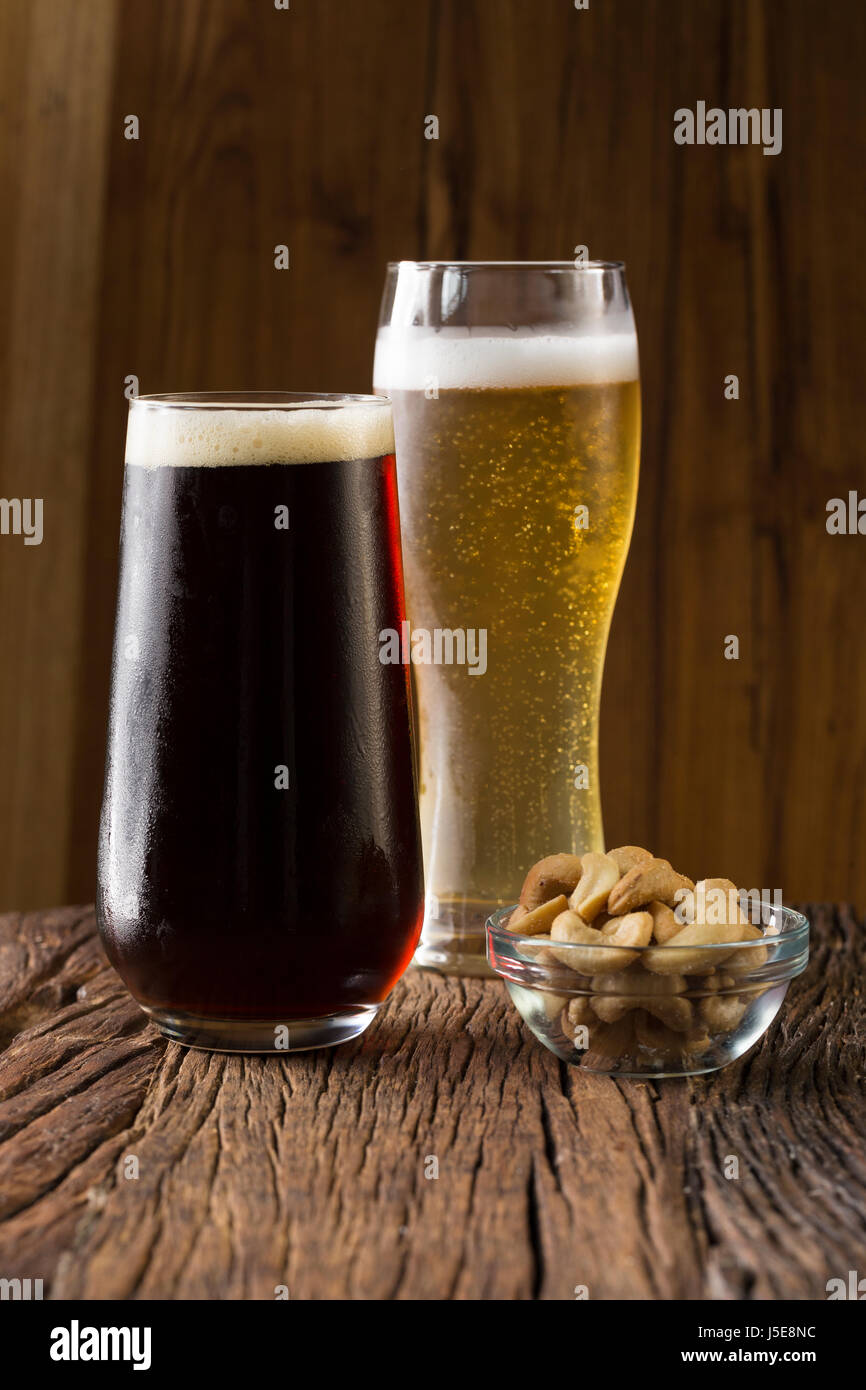 Zwei Pints Bier sitzen auf einer urigen Holzbar. Handgefertigte Mikrobrauerei Ale und Porter. Stockfoto