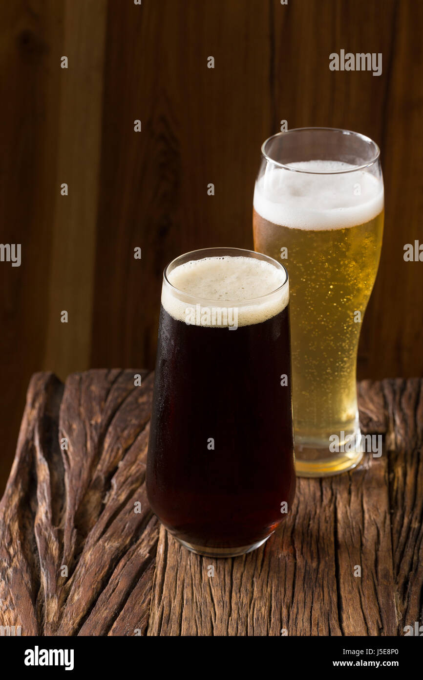 Zwei Pints Bier sitzen auf einer urigen Holzbar. Handgefertigte Mikrobrauerei Ale und Porter. Stockfoto
