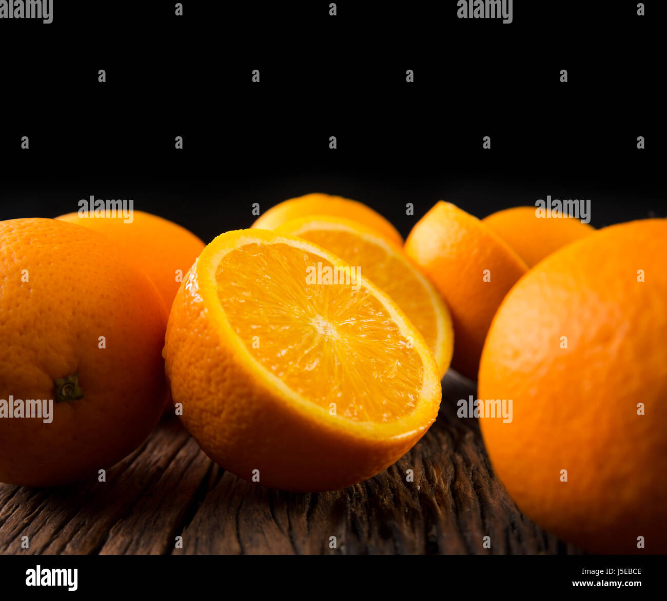 Ein Bunc Orangen auf einem rustikalen Holztisch sitzend. Stockfoto