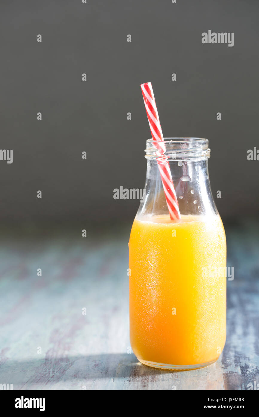 Flasche frisch gepressten Orangensaft auf einem rustikalen Holztisch sitzend. Stockfoto