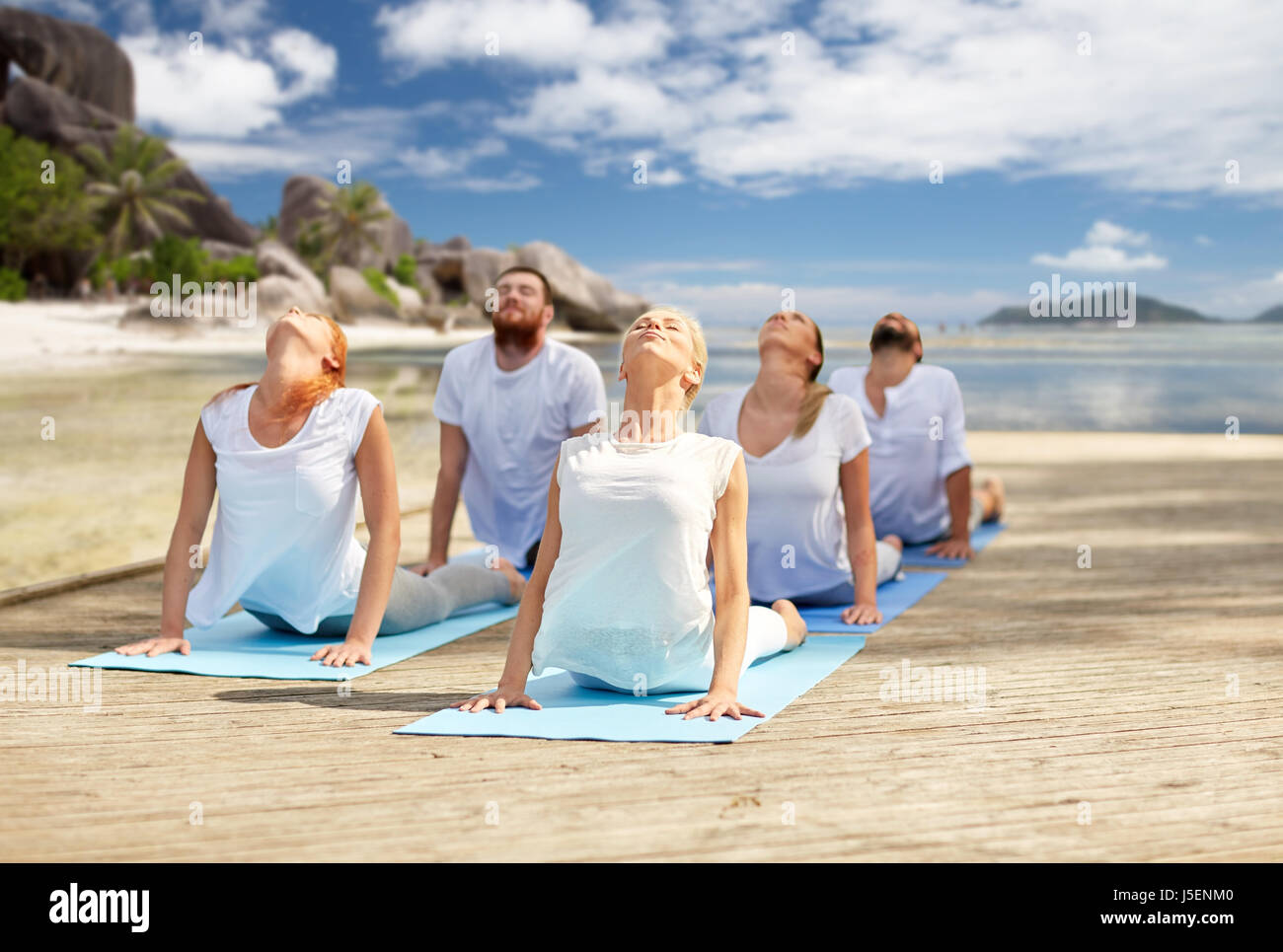 Gruppe von Menschen, die Yoga-Übungen über Strand Stockfoto