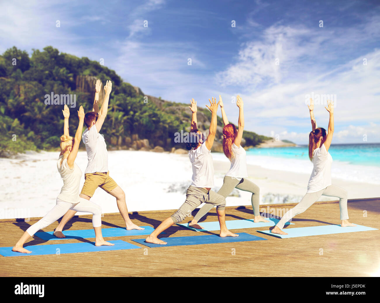 Gruppe von Menschen, die Yoga-Übungen am Strand Stockfoto