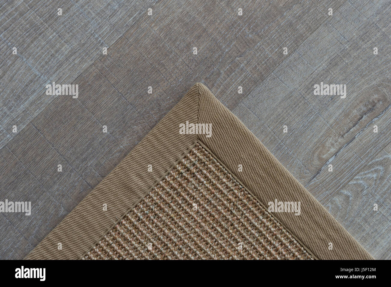 Ecke einer natürlichen Wolldecke auf einem Holzfußboden Stockfoto