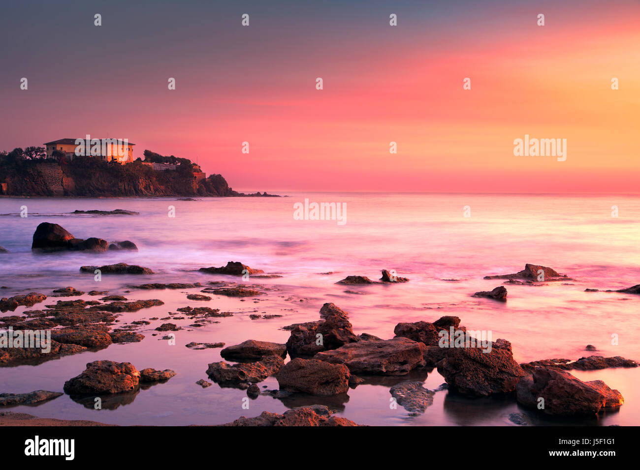 Castiglioncello Reiseziel, alten Gebäude auf die Felsen und das Meer bei Sonnenuntergang. Toskana, Italien, Europa. Langzeitbelichtung Stockfoto