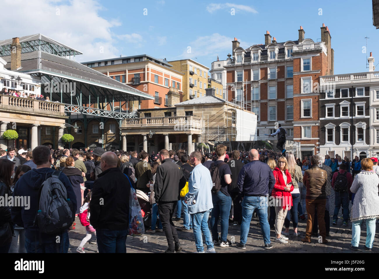 Touristen, die gerade einer Straße Entertainer in Covent Garden Market in London Stockfoto
