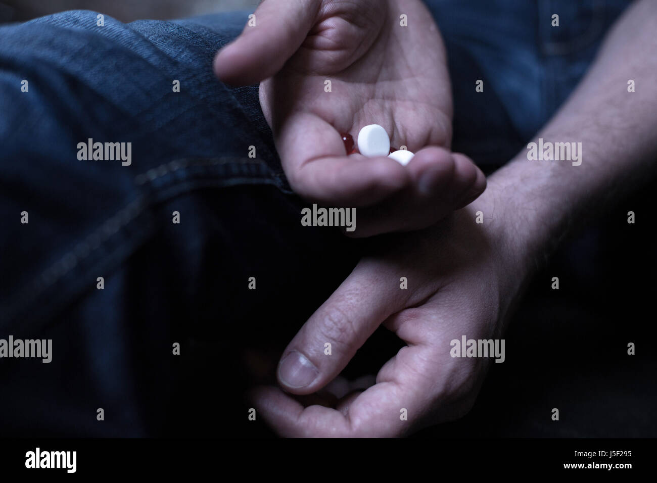 Reife Freak halten Kokain Pillen in der dunklen Ort Stockfoto