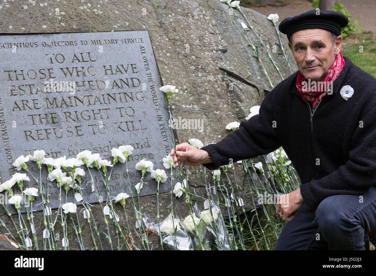 London, UK. 15. Mai 2017. Sir Mark Rylance stellt eine weiße Blume vor der Kriegsdienstverweiger Stein am Tavistock Square. Stockfoto