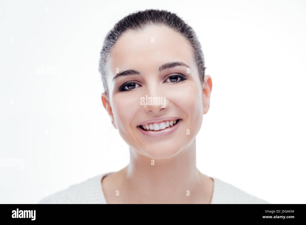 Lächelnd attraktive Frau mit strahlenden frische Gesichtshaut posiert auf weißem Hintergrund Stockfoto